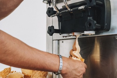 Une personne tranche un filet de saumon sur une planche en bois, avec des toasts préparés en premier plan.