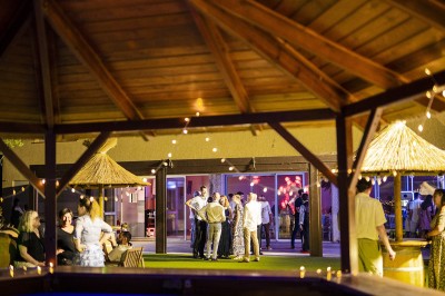 Une personne tranche un filet de saumon sur une planche en bois, avec des toasts préparés en premier plan.