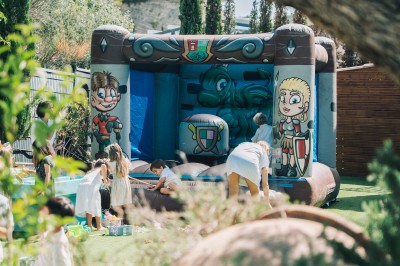 Une personne tranche un filet de saumon sur une planche en bois, avec des toasts préparés en premier plan.