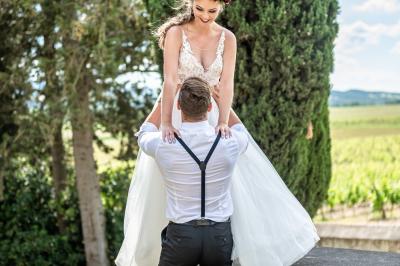 Un marié aide sa partenaire en robe de mariée à sortir d'une voiture ancienne décorée pour un mariage.