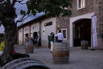 Un marié aide sa partenaire en robe de mariée à sortir d'une voiture ancienne décorée pour un mariage.