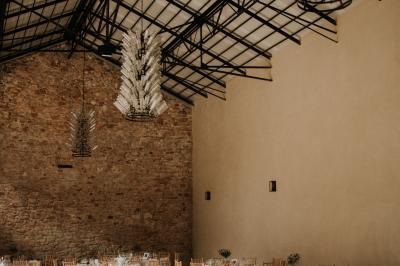 Un marié aide sa partenaire en robe de mariée à sortir d'une voiture ancienne décorée pour un mariage.