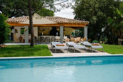 Salle en pierre avec de grandes tables dressées, éclairée par des lustres faits de bouteilles en verre vert.