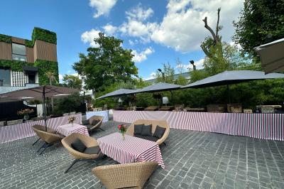 Salle de réception élégante avec tables rondes dressées, chaises transparentes et lustres suspendus.