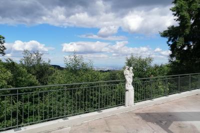 Vue aérienne d'une vallée verdoyante avec des collines, des villages et un ciel partiellement nuageux à l'horizon.