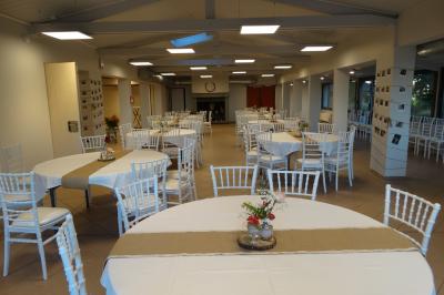 Vue aérienne d'une vallée verdoyante avec des collines, des villages et un ciel partiellement nuageux à l'horizon.