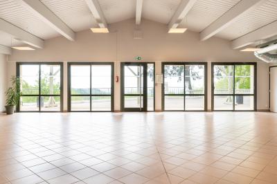 Vue aérienne d'une vallée verdoyante avec des collines, des villages et un ciel partiellement nuageux à l'horizon.