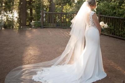 Vue aérienne d'une vallée verdoyante avec des collines, des villages et un ciel partiellement nuageux à l'horizon.