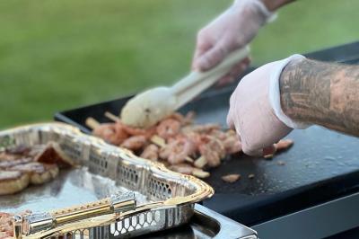 Deux flûtes décorées en cristal posées devant un gâteau à la crème et des fleurs blanches sur une table.
