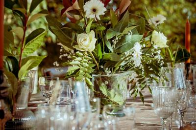 Deux flûtes décorées en cristal posées devant un gâteau à la crème et des fleurs blanches sur une table.
