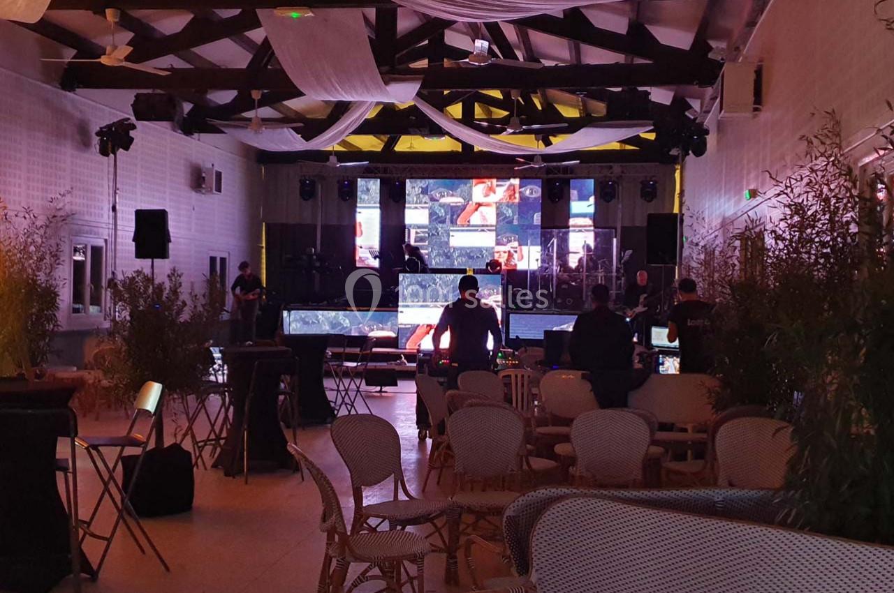 Salle décorée avec des écrans lumineux et des équipements techniques, préparée pour un événement ou une présentation.