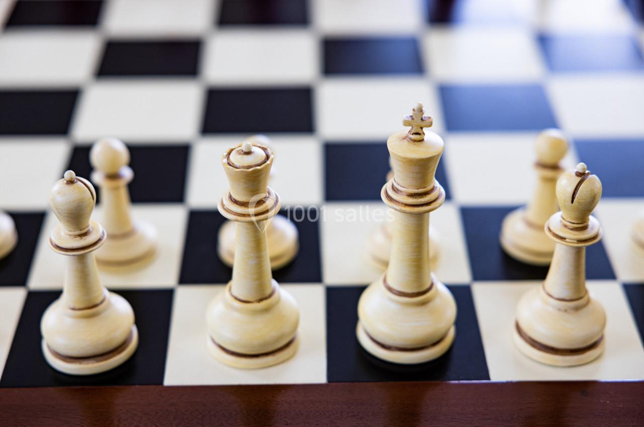 Pièces d'échecs en bois clair disposées sur un échiquier noir et blanc.