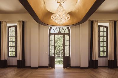 Vue aérienne d'un domaine viticole entouré de vignes, avec un plan d'eau visible à l'horizon.