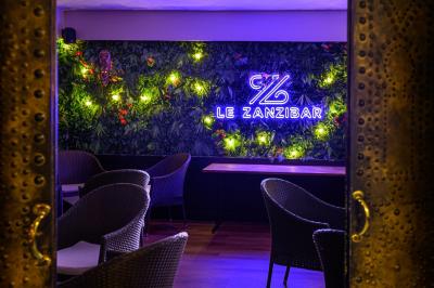 Assiette de beignets de poisson dorés sur lit de salade, décorée de rondelles de poivron et d'une garniture citronnée.