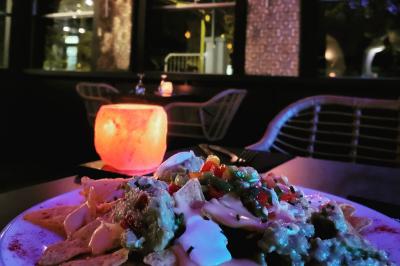 Plateau en bois garni de tacos variés avec garnitures colorées, présenté sur un fond décoratif.