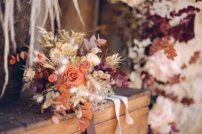 Des tables et chaises jaunes sont disposées sur une terrasse en plein air, près d'un arbre et d'un bâtiment clair.