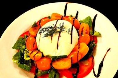 Assiettes garnies de viande rôtie, haricots verts, pommes de terre en dés et légumes décoratifs.