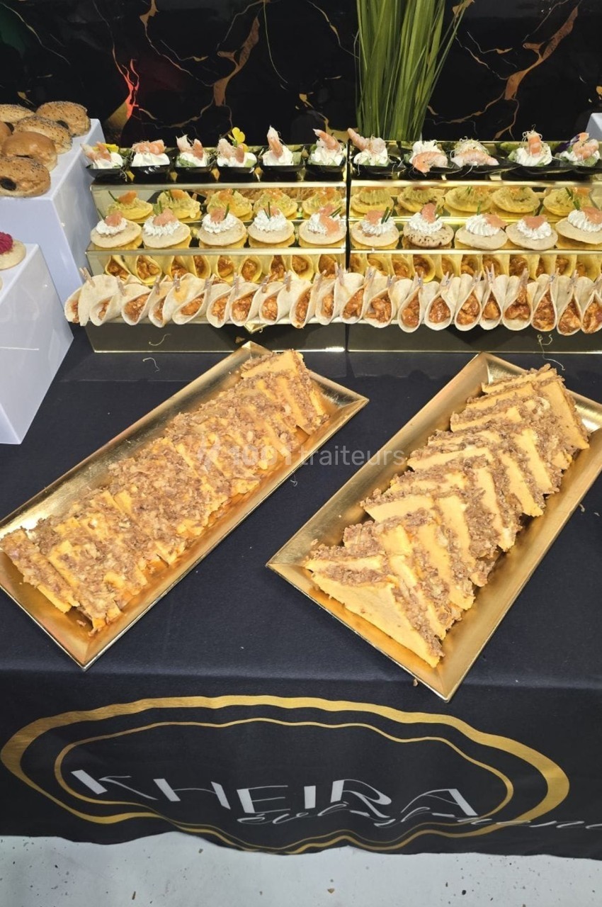 Plateau de desserts variés comprenant gâteaux, verrines et pâtisseries, présentés sur une table décorée.