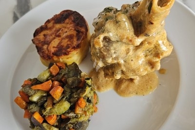 Assiettes garnies de viande rôtie, haricots verts, pommes de terre en dés et légumes décoratifs.