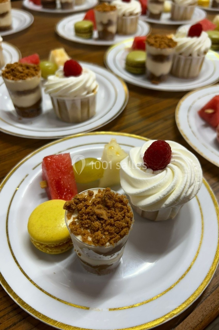 Assortiment de desserts sur une assiette, incluant verrines, macaron, fruits frais et pâtisseries.