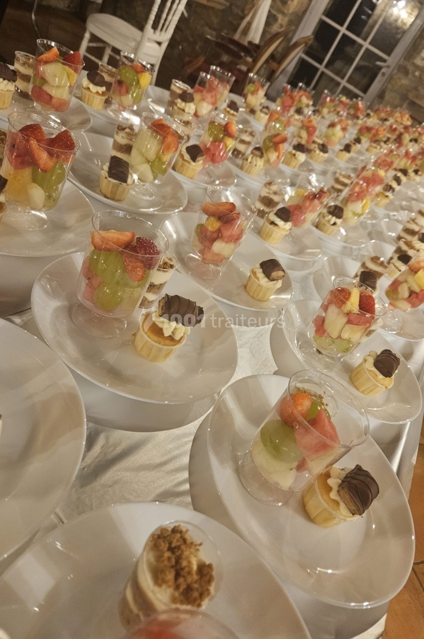 Desserts variés présentés sur des assiettes blanches, comprenant verrines de fruits et pâtisseries au chocolat.