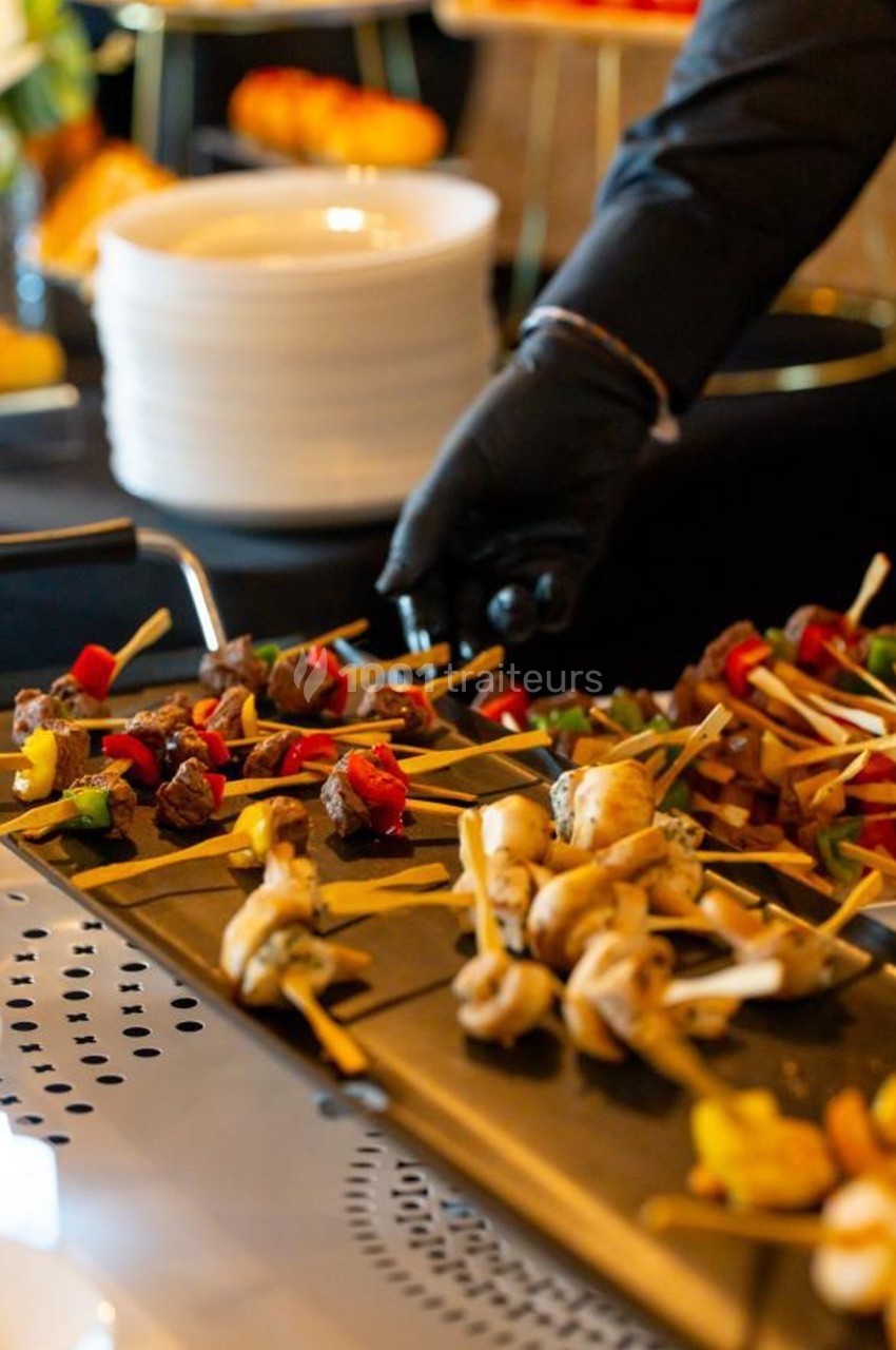 Brochettes variées de légumes et viandes grillées présentées sur un plateau lors d'un buffet.