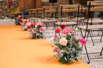 Salle de réception avec tables rondes dressées, décorées de fleurs, bougies et couverts élégants.