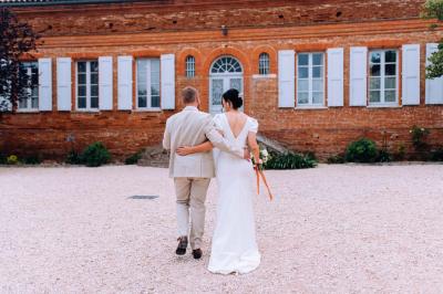 Salle de réception avec tables rondes dressées, décorées de fleurs, bougies et couverts élégants.