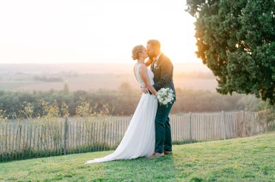 Salle de réception avec tables rondes dressées, décorées de fleurs, bougies et couverts élégants.