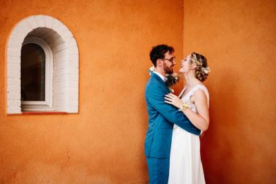 Salle de réception avec tables rondes dressées, décorées de fleurs, bougies et couverts élégants.