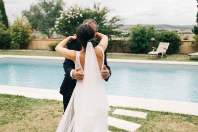 Salle de réception avec tables rondes dressées, décorées de fleurs, bougies et couverts élégants.