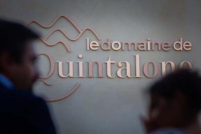 Salle de réception avec tables rondes dressées, décorées de fleurs, bougies et couverts élégants.