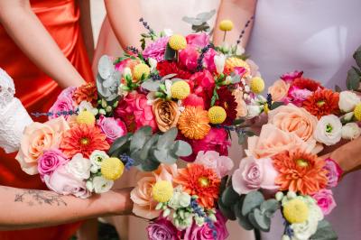 Salle de réception avec tables rondes dressées, décorées de fleurs, bougies et couverts élégants.