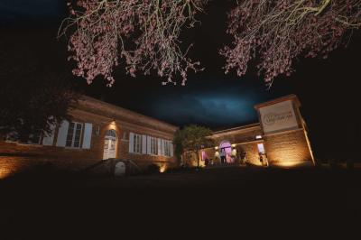Salle de réception avec tables rondes dressées, décorées de fleurs, bougies et couverts élégants.