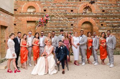 Salle de réception avec tables rondes dressées, décorées de fleurs, bougies et couverts élégants.