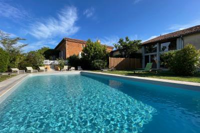 Salle de réception avec tables rondes dressées, décorées de fleurs, bougies et couverts élégants.