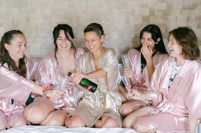 Salle de réception avec tables rondes dressées, décorées de fleurs, bougies et couverts élégants.