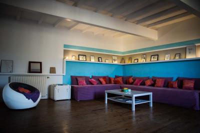 Salle de réception avec tables rondes dressées, décorées de fleurs, bougies et couverts élégants.