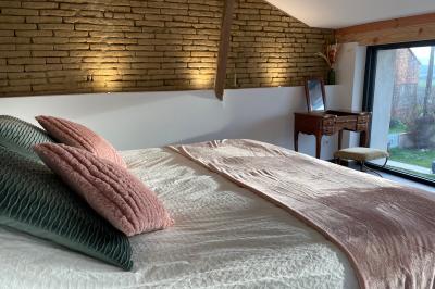 Salle de réception avec tables rondes dressées, décorées de fleurs, bougies et couverts élégants.