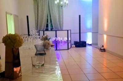 Un verre de champagne est rempli depuis une bouteille, entouré de trois autres verres sur une table en bois.