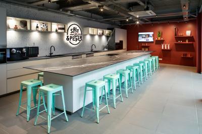 Espace salon avec canapés colorés, coussins variés, tables basses en bois et murs en pierre dans un cadre chaleureux.