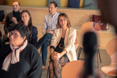Deux femmes en tablier rouge discutent en préparant des ingrédients dans une cuisine moderne.
