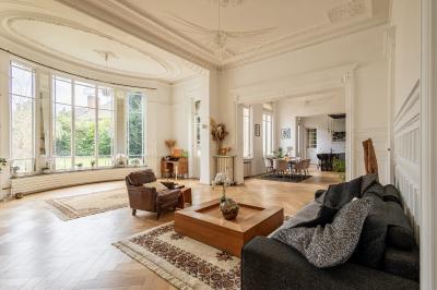 Salle de bain avec baignoire encastrée, douche à l'italienne, carrelage noir marbré et mosaïque dorée.