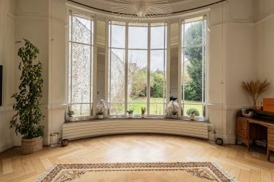 Salle de bain avec baignoire encastrée, douche à l'italienne, carrelage noir marbré et mosaïque dorée.