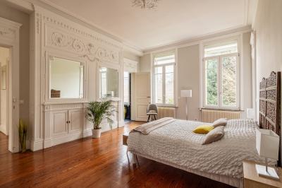 Salle de bain avec baignoire encastrée, douche à l'italienne, carrelage noir marbré et mosaïque dorée.