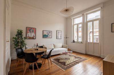 Salle de bain avec baignoire encastrée, douche à l'italienne, carrelage noir marbré et mosaïque dorée.