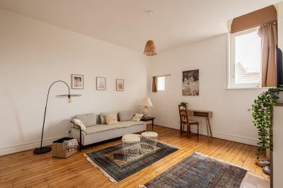 Salle de bain avec baignoire encastrée, douche à l'italienne, carrelage noir marbré et mosaïque dorée.
