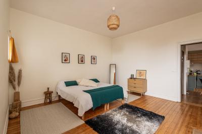 Salle de bain avec baignoire encastrée, douche à l'italienne, carrelage noir marbré et mosaïque dorée.
