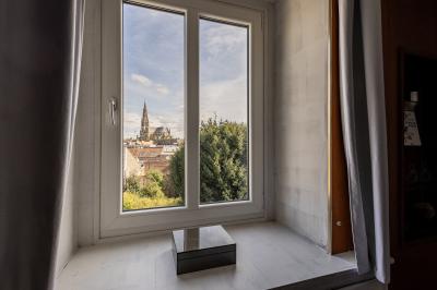 Salle de bain avec baignoire encastrée, douche à l'italienne, carrelage noir marbré et mosaïque dorée.