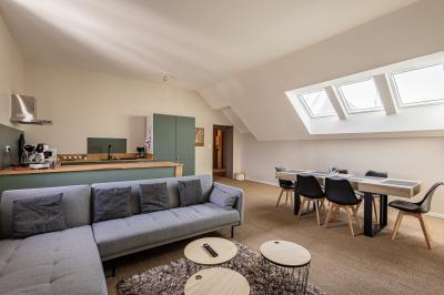 Salle de bain avec baignoire encastrée, douche à l'italienne, carrelage noir marbré et mosaïque dorée.